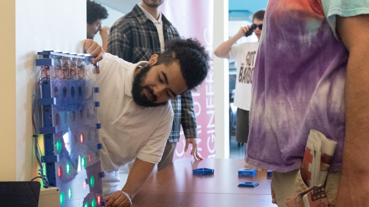 A student showing their project to a bystander