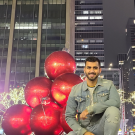 Student Muhammad D Arshad poses in front of holiday decor